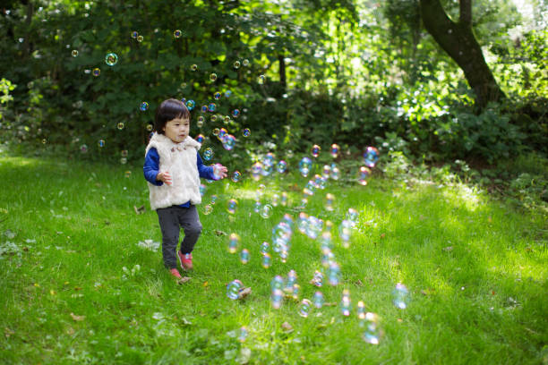 istock baby girl play bubble at Spring garden 1065186146