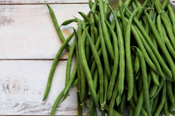 istock Green beans on with tomato on the wooden table. 1065188208