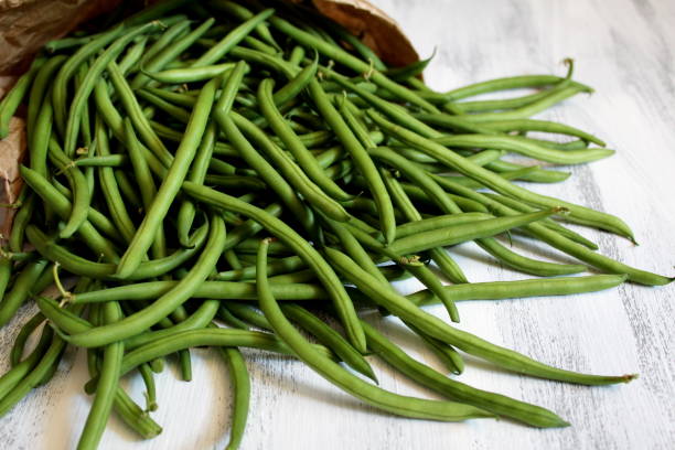 istock Green beans on with tomato on the wooden table. 1065188390