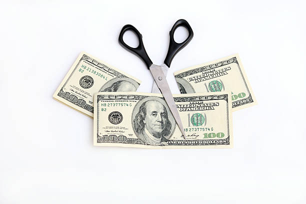 dólares e tesoura - cutting currency scissors home finances - fotografias e filmes do acervo