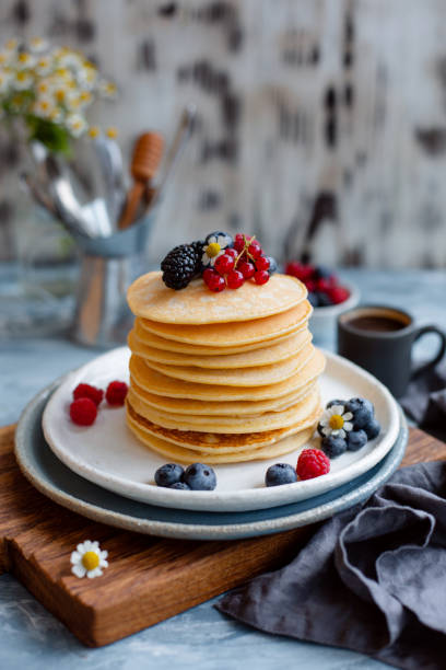 istock Fluffy pancakes on breakfast table with coffee in morning light. Close-up. 1065206218