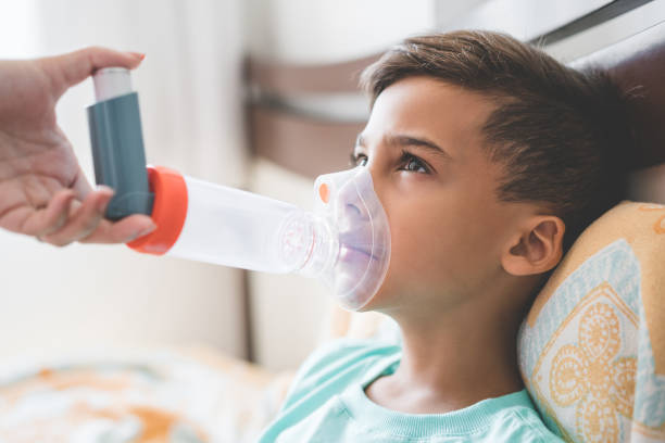 astmy - asthmatic child asthma inhaler inhaling zdjęcia i obrazy z banku zdjęć