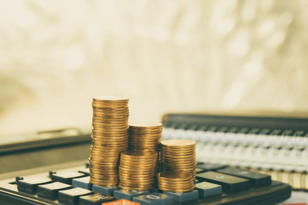 istock Coin stack and financial graph paper sheet with calculator on working table, business planning vision and finance analysis concept. 1065217988