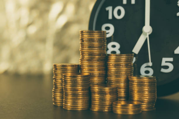 istock Alarm clock and coins stacks on working table, time for savings money concept, banking and business concept 1065218008