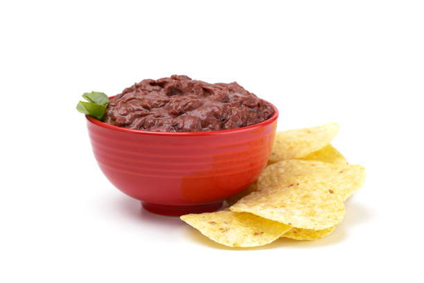 A Bowl of Black Bean Dip with Chips on a White Background