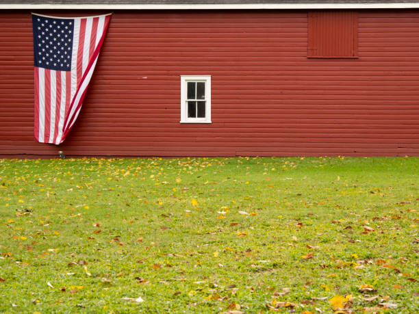 American flag on the side of a red barn stock photo