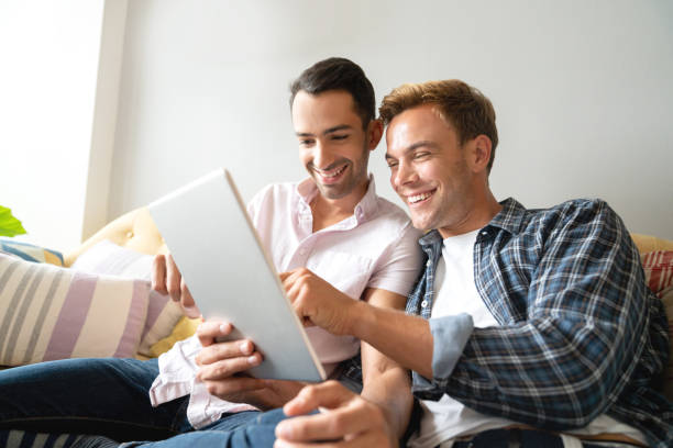 istock Loving homosexual couple social networking at home on a tablet computer 1065230624