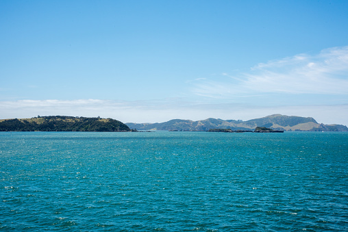 Stunning turquoise Tasman Sea and lush, green island view in the Bay of Islands, New Zealand