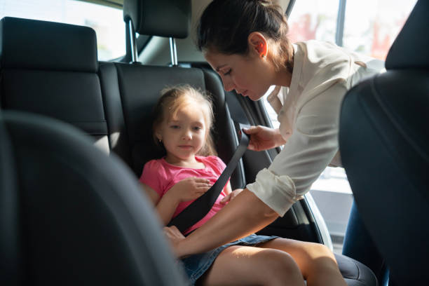 istock Mother fastening seat belt on her daughter 1065238462