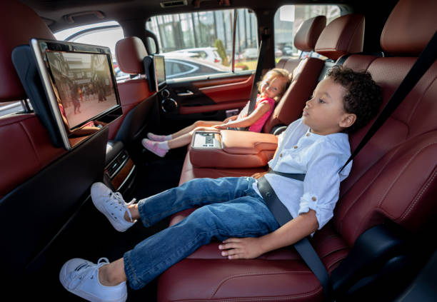 istock Happy kids watching television in a car while wearing their seat belt fastened 1065238486