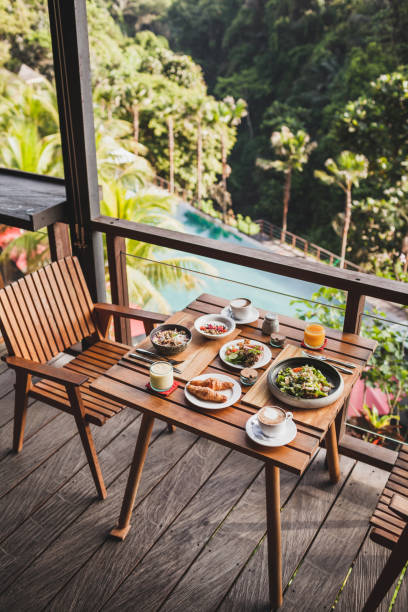 istock Table with served breakfast on wooden terrace with pool and jungle view in Bali 1065243396