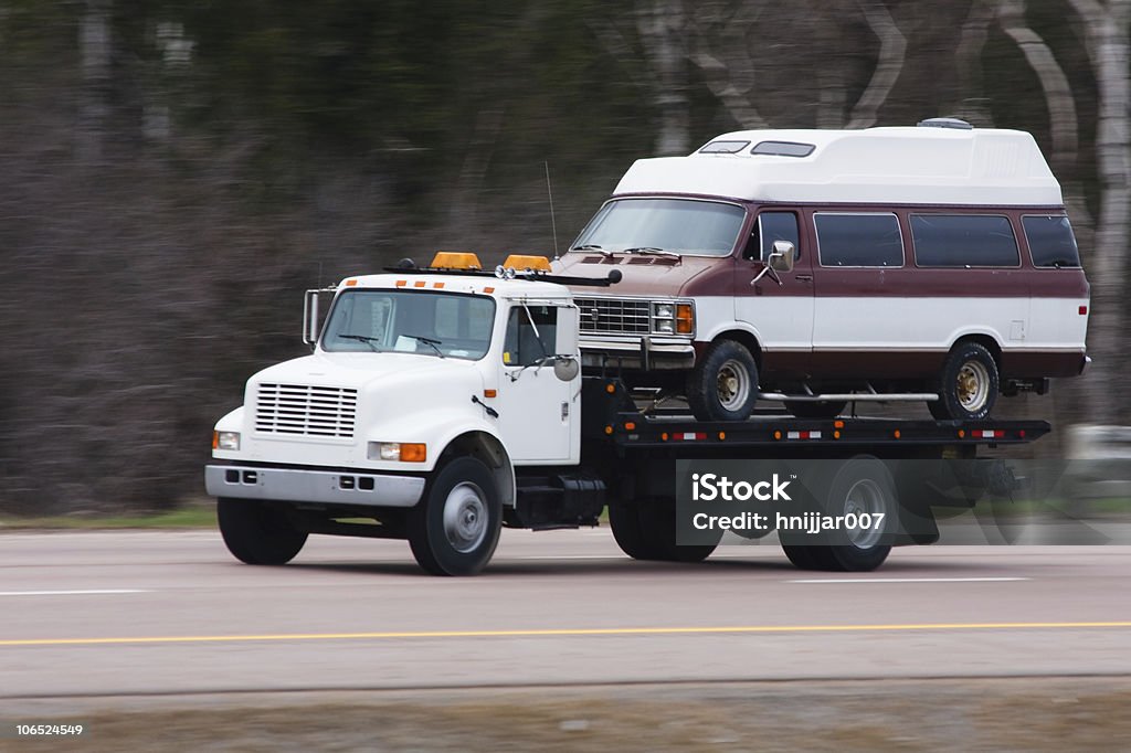 Flatbed truck transporting a van  Tow Truck Stock Photo