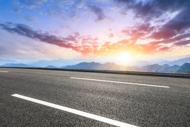 istock Asphalt road and mountains at beautiful sunset 1065252004