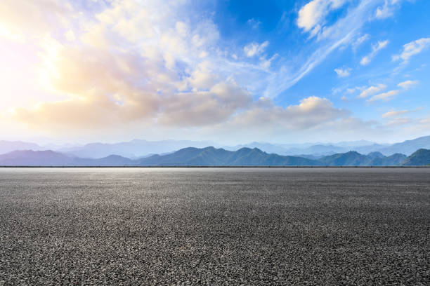 istock Asphalt road and mountains at beautiful sunset 1065252006
