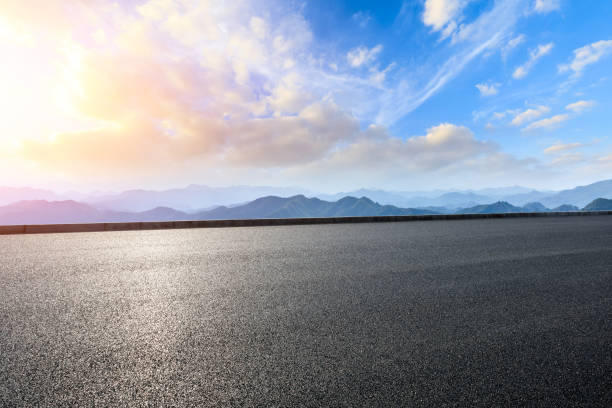 istock Asphalt road and mountains at beautiful sunset 1065252220