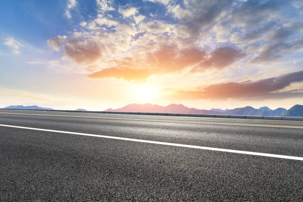 istock Asphalt road and mountains at beautiful sunset 1065252644