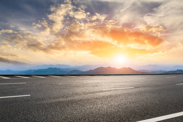 istock Asphalt road and mountains at beautiful sunset 1065252820