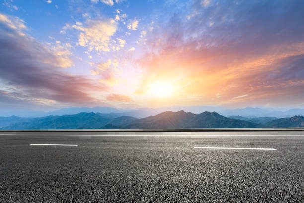 istock Asphalt road and mountains at beautiful sunset 1065252964