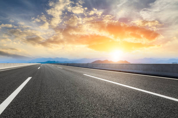 istock Asphalt road and mountains at beautiful sunset 1065254306
