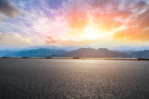 istock Asphalt road and mountains at beautiful sunset 1065254456