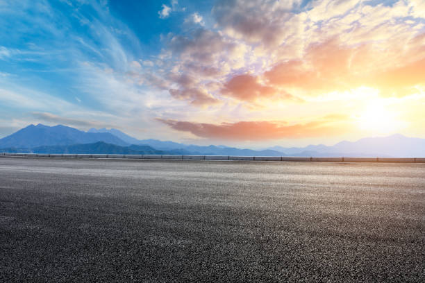istock Asphalt road and mountains at beautiful sunset 1065254542