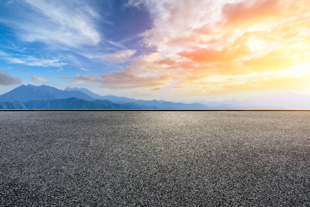 istock Asphalt road and mountains at beautiful sunset 1065255140