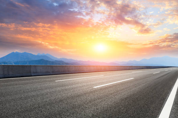 istock Asphalt road and mountains at beautiful sunset 1065255442