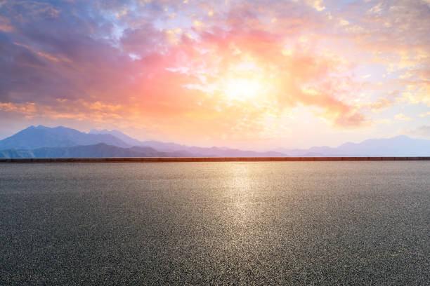 istock Asphalt road and mountains at beautiful sunset 1065256558
