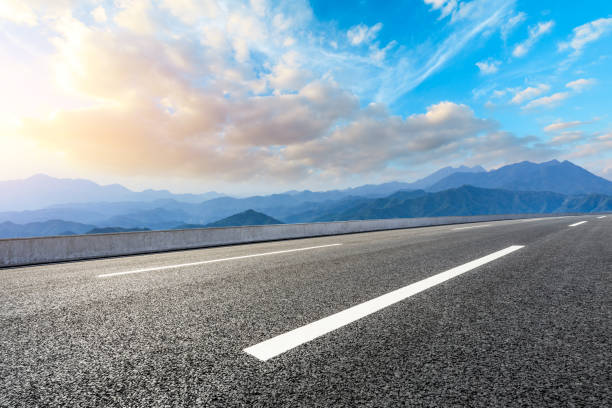 istock Asphalt road and mountains at beautiful sunset 1065256560