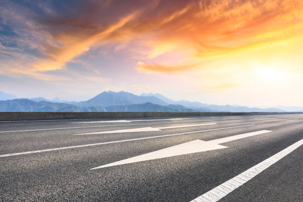 istock Asphalt road and mountains at beautiful sunset 1065256562