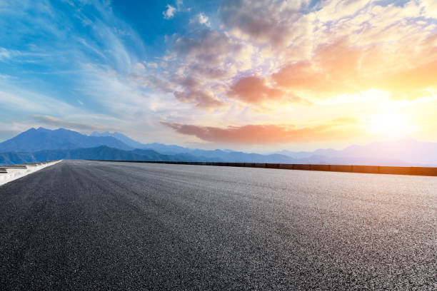 istock Asphalt road and mountains at beautiful sunset 1065256610