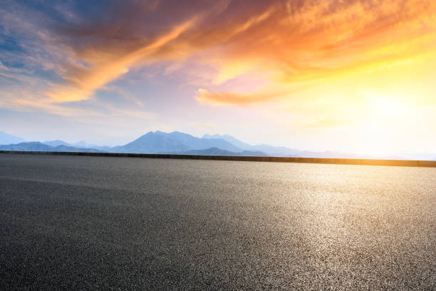 istock Asphalt road and mountains at beautiful sunset 1065256640