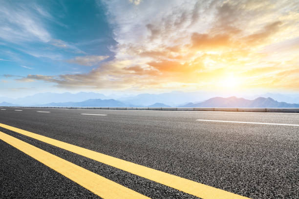 istock Asphalt road and mountains at beautiful sunset 1065256974