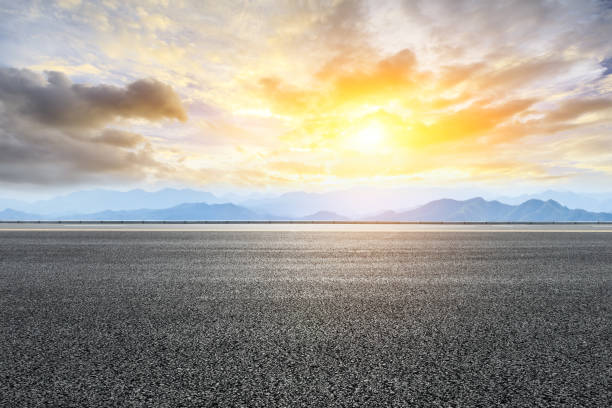 istock Asphalt road and mountains at beautiful sunset 1065257180