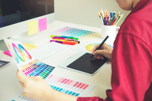 istock Freelance creative designers working on desk using digital graphic tablet and drawing with pen in modern home office. 1065257214