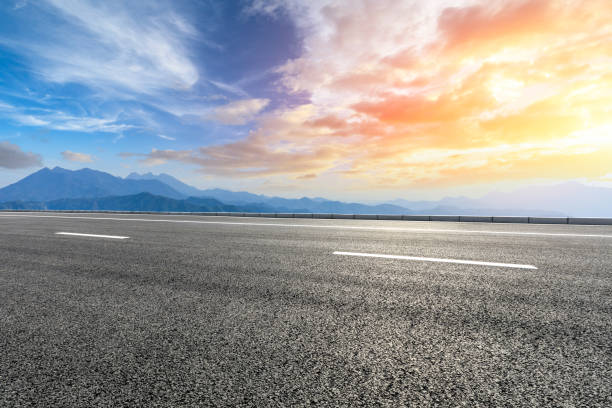 istock Asphalt road and mountains at beautiful sunset 1065257228