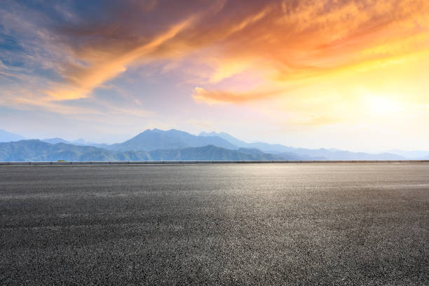 istock Asphalt road and mountains at beautiful sunset 1065257278