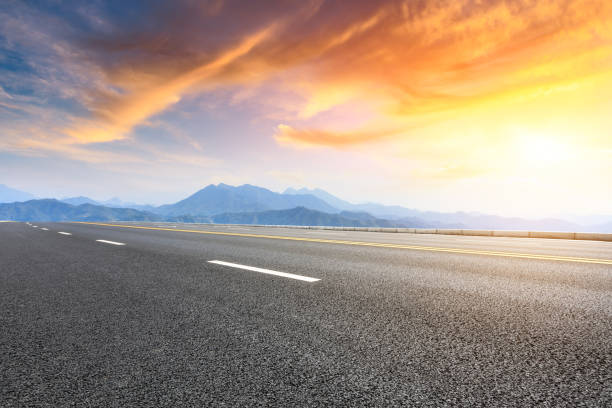 istock Asphalt road and mountains at beautiful sunset 1065259520