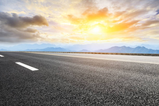 istock Asphalt road and mountains at beautiful sunset 1065259522