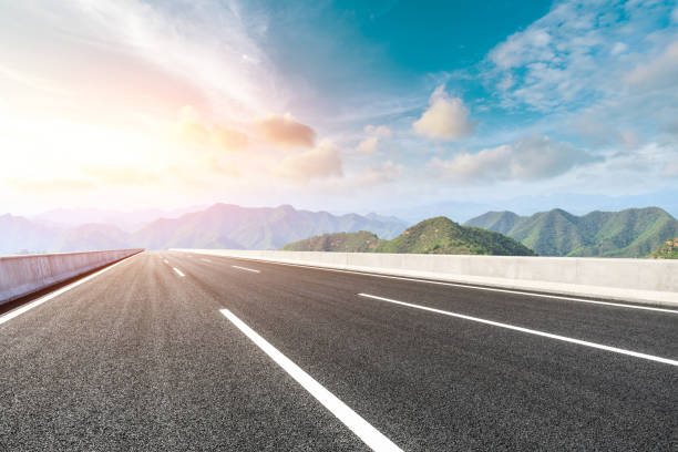 istock Asphalt road and mountains at beautiful sunset 1065259720