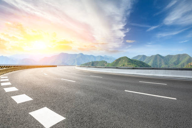 istock Asphalt road and mountains at beautiful sunset 1065260040