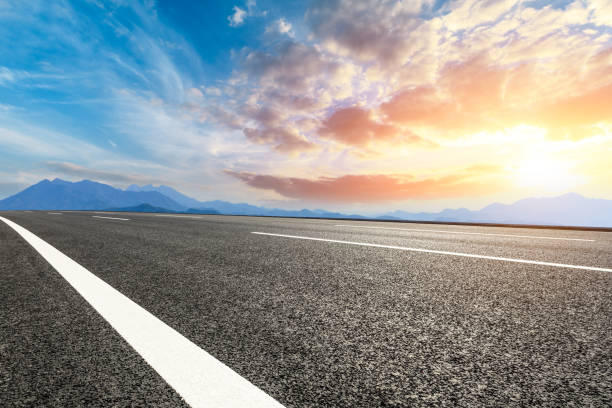 istock Asphalt road and mountains at beautiful sunset 1065261140