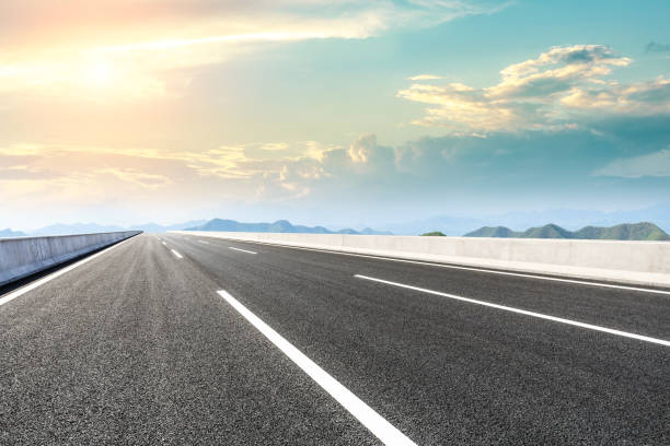 istock Asphalt road and mountains at beautiful sunset 1065261284