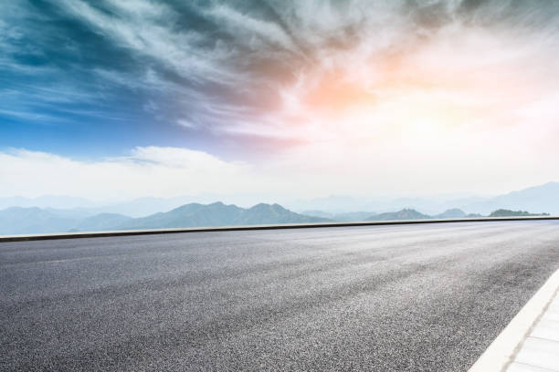 istock Asphalt road and mountains at beautiful sunset 1065261758