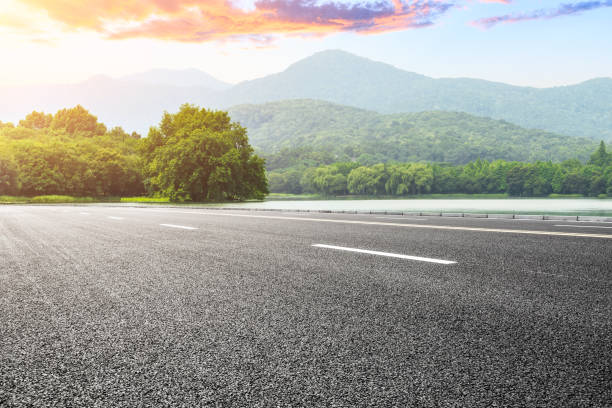 istock Asphalt road and mountains at beautiful sunset 1065263218