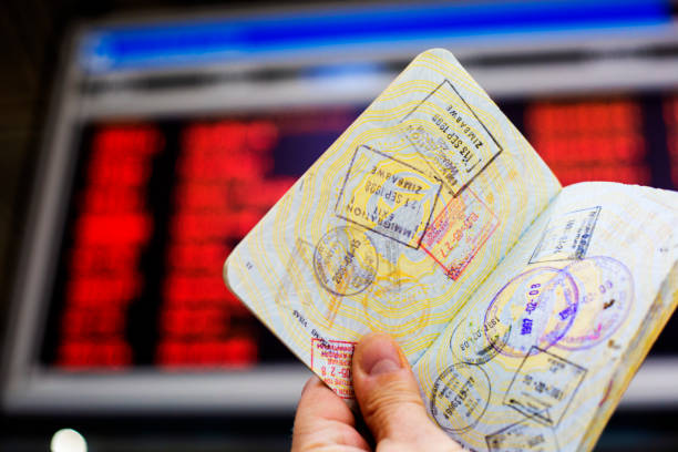 Close up of fingers holding a passport for travelling, airport, “Reisepass Passport”
