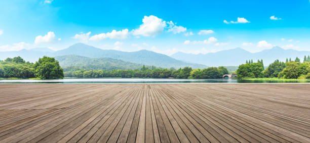 istock Wood floor and green mountain with clouds 1065268268