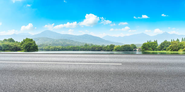 istock Asphalt road and mountains with white clouds 1065270922