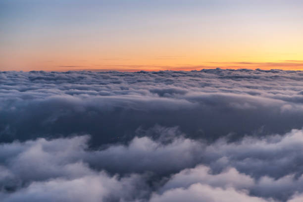 istock Flying above the clouds at sunset. view from the airplane window 1065270962