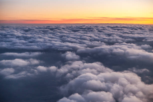 istock Flying above the clouds at sunset. view from the airplane window 1065270964